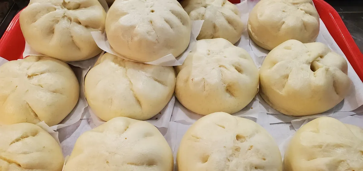 Multiple steamed buns on a red tray